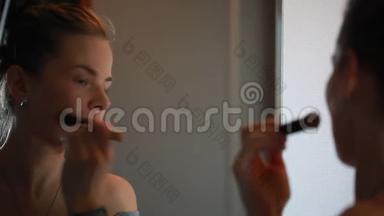 女人正在用刷子化妆