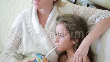 母亲对待生病的孩子.. 妈妈帮助一个小女孩康复。 温度计