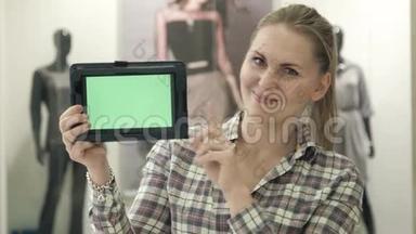 那个女孩在商场里用绿色屏幕展示平板电脑