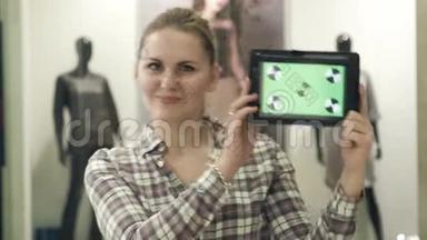 那个女孩在<strong>商场</strong>里用<strong>绿色</strong>屏幕展示平板电脑