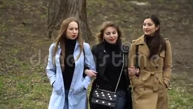 女孩的友谊。 三个年轻漂亮的女孩在城市公园散步。 他们很开心。 女孩们很高兴认识