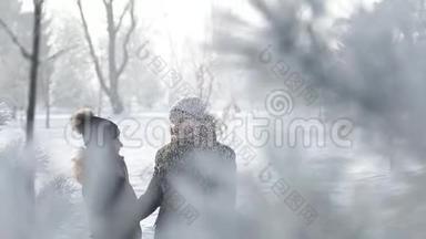 一个年轻人和一个穿着温暖冬天衣服的女孩，在一个下雪的冬天公园里享受彼此的存在