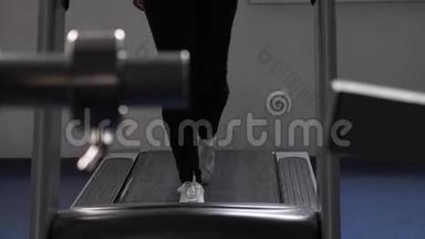 通过走路加强腿部肌肉.. 特写镜头。 在健身房散步。 心脏负荷。 女孩在跑步机上训练。 健身健身