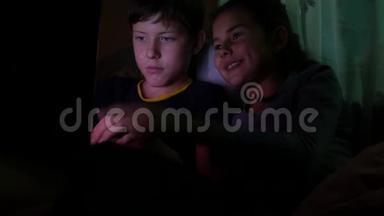儿童男孩和女孩在儿童夜间上网游戏中玩笔记本电脑