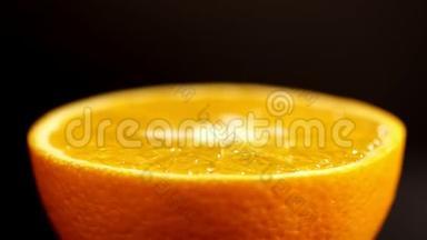 橙色在一个区域靠近。 黑色背景上明亮的柑橘橙色。 明亮的橙色围绕着自己旋转
