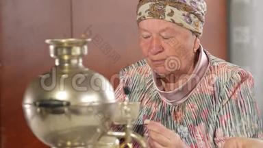 一对老夫妇正在喝一杯老式俄罗斯水壶萨莫瓦尔的茶。 一个留胡子的男人和他妻子在