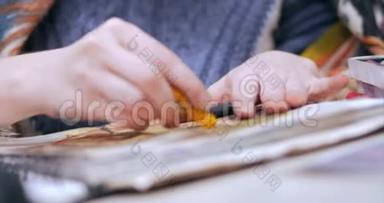 艺术家的年轻双手，女艺术家用石墨<strong>铅笔</strong>绘制画布，坐在桌子上<strong>画画</strong>布