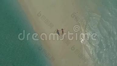 在菲律宾热带岛屿的白色海滩上放松的可爱旅行情侣的空中景观
