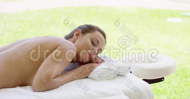 可爱的中年妇女躺在按摩床上