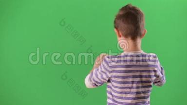 男孩在智能手机上拍摄视频。 绿色屏幕