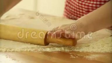 面包师用擀面杖揉面团。 女人用面团做披萨。 做披萨的面团。 滚动面团