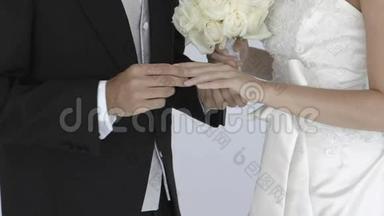 新婚新郎在新娘手指上滑动结婚戒指