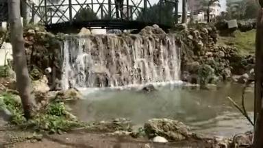 特写小瀑布和大自然中的绿色植物.. 土耳其安塔利亚阳光明媚的一天，公园里的小瀑布。
