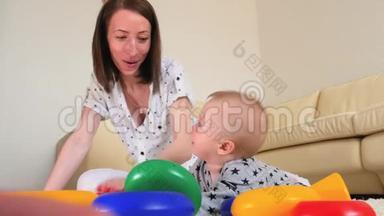 可爱的母亲和孩子在家里一起在室内玩耍。 爱妈妈和幼儿玩耍，玩得开心
