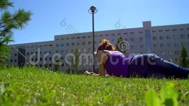 一个戴眼镜的女孩在草地上看书