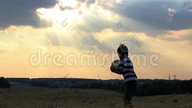 男孩在日落时分在球场上<strong>打球</strong>，男孩梦想成为一名足球运动员