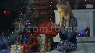 一个小女孩<strong>坐在</strong>圣诞<strong>树下</strong>，正在考虑礼物