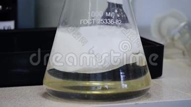 实验室玻璃Erlenmeyer锥形瓶，装满化学白色液体，用于科学化学实验