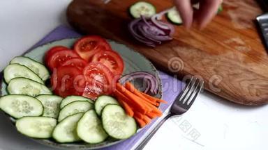 切蔬菜做清淡的沙拉。 素食。 健康的饮食。 西红柿，黄瓜，胡萝卜和红葱..