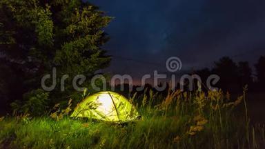 夜晚在帐篷上方移动星星和云彩。 夜晚时光流逝。