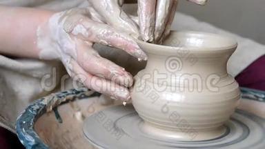 女人用她的双手<strong>托起</strong>壁壶，在圆圈上用粘土雕刻