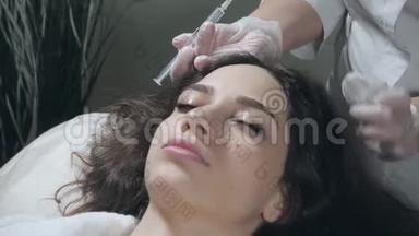 英俊的女人头部受到注射。 这个程序使医生戴着白手套。 中间疗法的概念