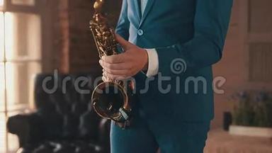 穿着<strong>蓝色</strong>西装的萨克斯演奏家在<strong>舞台</strong>上用金色萨克斯管演奏爵士乐。 优雅。