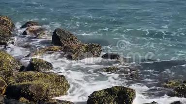 一股巨浪击中岩石。 波浪<strong>撞击</strong>热带海滩上的岩石，形成飞溅的形状。 在岩石上的强大波浪