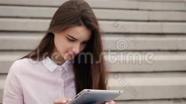 年轻漂亮的学生女孩在外面用平板电脑。 很漂亮的<strong>少女</strong>在空中<strong>看书</strong>。