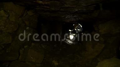 地下研究人员在地下隧道中攀爬。 穿过石块堵塞。