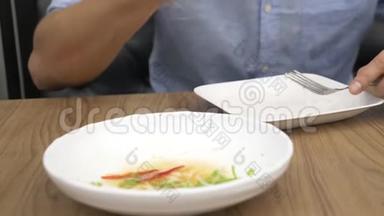 泰国菜-米饭，煎蛋卷，蔬菜和猪肉。 一个男人在餐馆吃泰国菜。 4k，慢动作