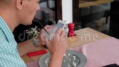 一个成熟的男人在咖啡馆里用烤面包和鸡蛋吃早餐