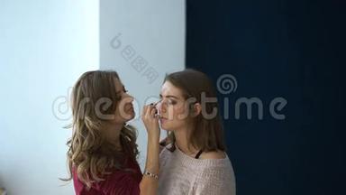 化妆师在一个重要的活动之前为一个女孩的<strong>眼睛化妆</strong>