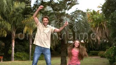 快乐的父亲和女儿跳在蹦床上