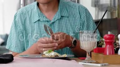 一个成熟的男人在咖啡馆里用烤面包和鸡蛋吃早餐