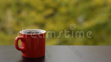 热腾腾的热气腾腾的咖啡放在红杯里，室外的咖啡桌