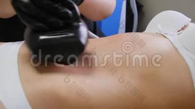 这位瘦女人躺在水疗沙龙时，正在用液化石油气工具接受腹部真空按摩。 Cosmetology
