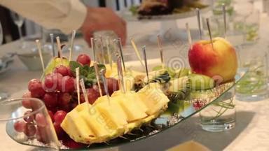 不同的新鲜水果在婚礼自助餐桌上。 水果和浆果婚礼桌装饰。 婚礼，新年