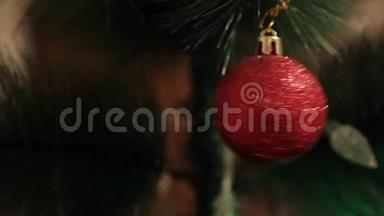 年轻女士在圣诞树上挂圣诞球。 圣诞玩具挂在装饰精美的圣诞树上