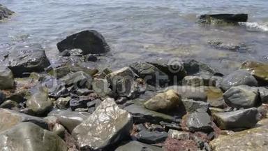 正面看海浪在岩石上破碎。 岩石与大海中的大石头和波浪与泡沫。