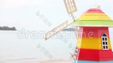 五颜六色的风轮机家居装饰对象在海边。