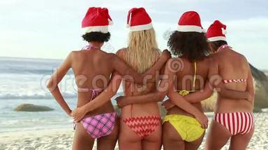 四个女孩戴着圣诞帽互相拥抱