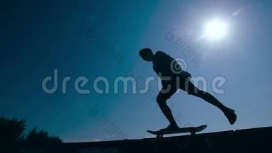 滑板运动员剪影滑板在天空背景日落。 慢动作。