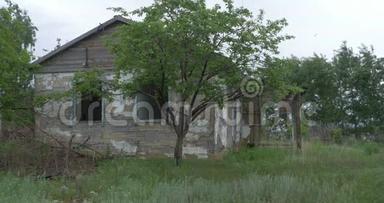 村里一座废弃的老房子，在树的背景上。 顿涅茨克附近被遗弃的房子。 毁坏的房屋和