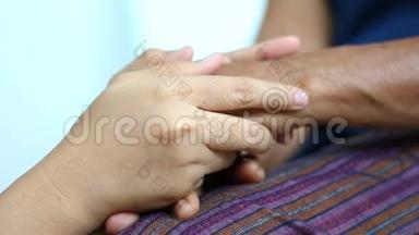 年轻女子的双手握着，温柔地抚摸着老年妇女的双手，隐喻和<strong>肢体</strong>语言的概念，感受爱，抚慰和抚慰