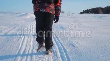 团队合作。 男游客摄影师在冬天乘三脚架爬<strong>山顶山顶</strong>岩峰群去雪