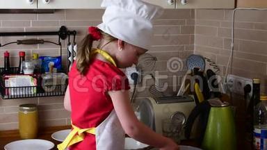 可爱的小<strong>女孩</strong>做晚餐。 小<strong>女孩</strong>在厨房准备食物。 可爱的小<strong>女孩</strong>打扮得像个厨师。