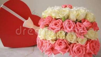 精致的粉色和白色玫瑰花束.. 有礼物的盒子，以心脏的形式