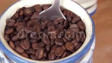 咖啡颗粒被倒入咖啡研磨机中。 从存放咖啡的容器中取出咖啡粒倒入手中