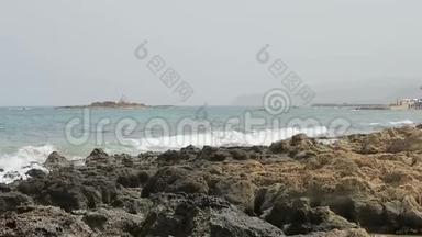 希腊克里特岛马利亚湾斯塔利斯海滩景观。 人们喜欢海滩。 水中的岩石。 酒吧和餐馆